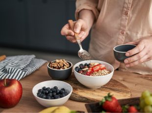 Kom met havervlokken, blauwe bessen, aardbeien en noten: een ontbijt dat helpt om je cholesterol te verlagen